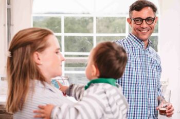 Vater l&auml;chelt Mutter mit Baby an