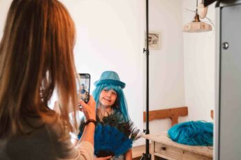 Mutter fotografiert Kind mit t&uuml;rkiser Per&uuml;cke