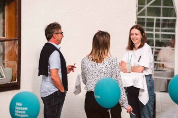 Personen am Stehtisch im Gespr&auml;ch