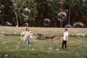 P&auml;rchen spielt auf der Wiese mit riesigen Seifenblasen