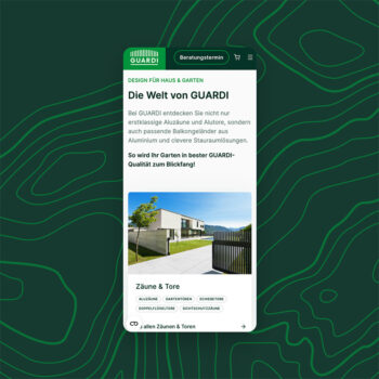 Auf dem Bildschirm eines Mobiltelefons wird die GUARDI Website angezeigt, die ein modernes Haus mit einem Metallzaun und einem Tor unter blauem Himmel zeigt. Auf der Seite werden Produkte f&uuml;r Haus und Garten vorgestellt, darunter Z&auml;une und Tore.