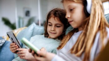 Zwei M&auml;dchen spielen auf Tablets