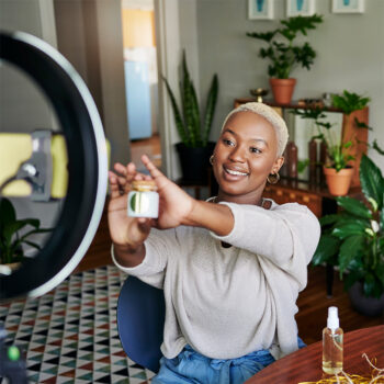 M&auml;dchen h&auml;lt Produkt vor ein Ringlicht