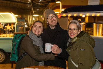 Chris mit zwei Kundinnen, alle l&auml;cheln