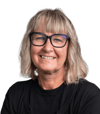 L&auml;chelnde Frau mit schulterlangen blonden Haaren, die eine schwarz gerahmte Brille und ein schwarzes Oberteil tr&auml;gt, posiert vor einem schlichten wei&szlig;en Hintergrund.